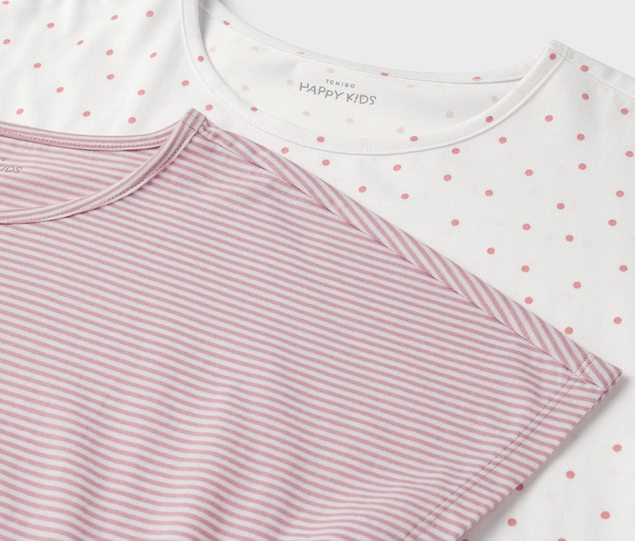 Detail von zwei T-Shirts: eines weiß mit rosa Punkten, das andere rosa mit weißen Streifen.