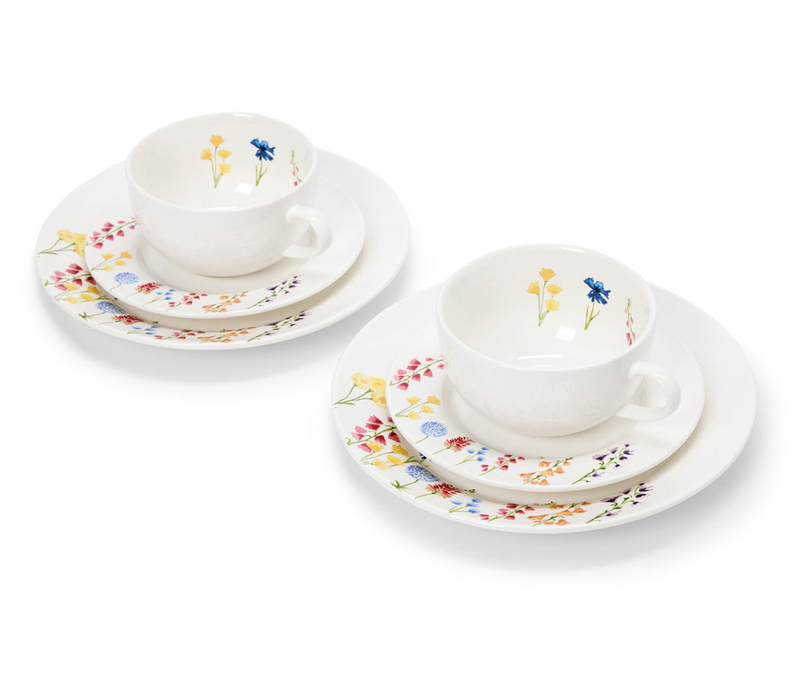 Zwei weiße Tassen mit Blumenmuster auf Tellern.
