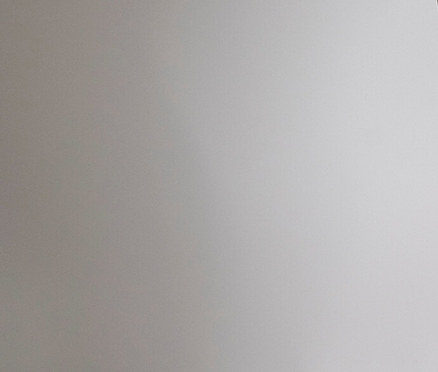 Seitenansicht einer Frau in Spitzenunterwäsche und einer Jeansjacke über den Schultern.