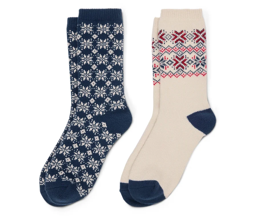 Zwei Socken: eine marineblaue Socke mit weißen Schneeflocken und eine beige Socke mit roten und blauen Mustern.