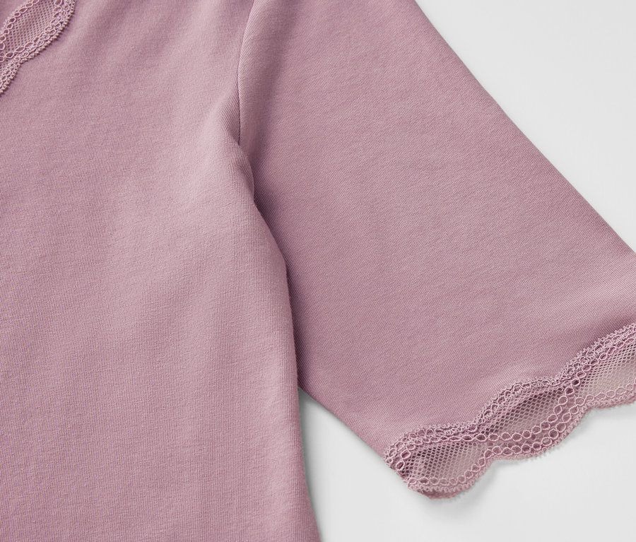 Detailaufnahme eines lilafarbenen T-Shirts mit kurzen Ärmeln und Spitzenbesatz.