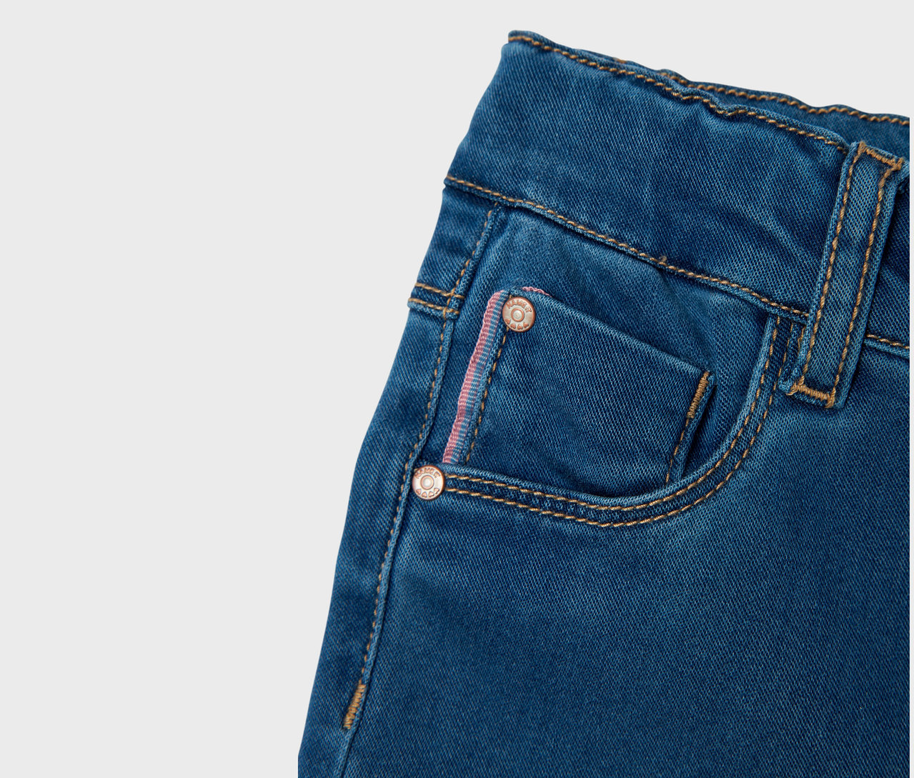 Nahaufnahme von blauen Jeans mit einer kleinen Tasche und Nähten.