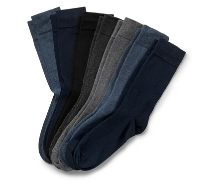 Mehrere einfarbige Socken in verschiedenen Grautönen und Blautönen liegen nebeneinander.