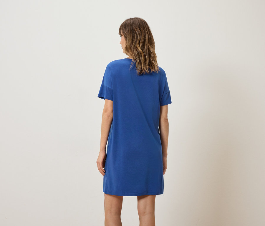 Frau von hinten, die ein blaues T-Shirt-Kleid trägt.
