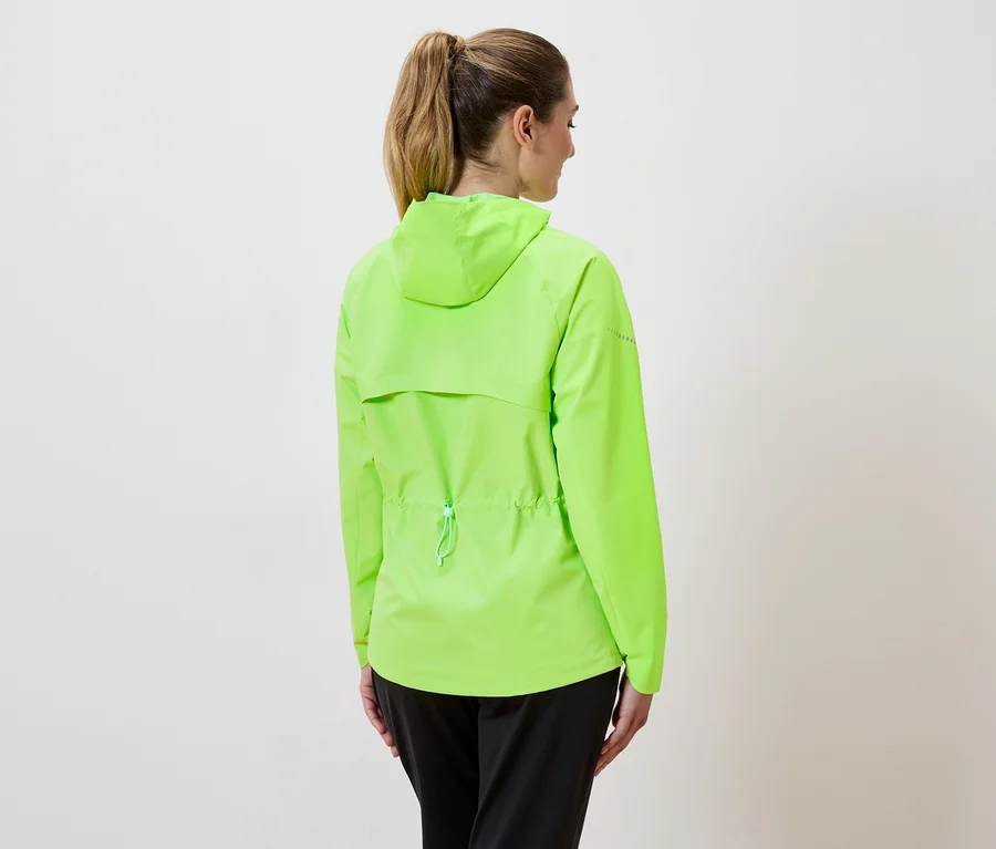 Frau mit Pferdeschwanz trägt eine neongrüne Jacke mit Kapuze und Kordelzug und schwarze Hose, von hinten gesehen.