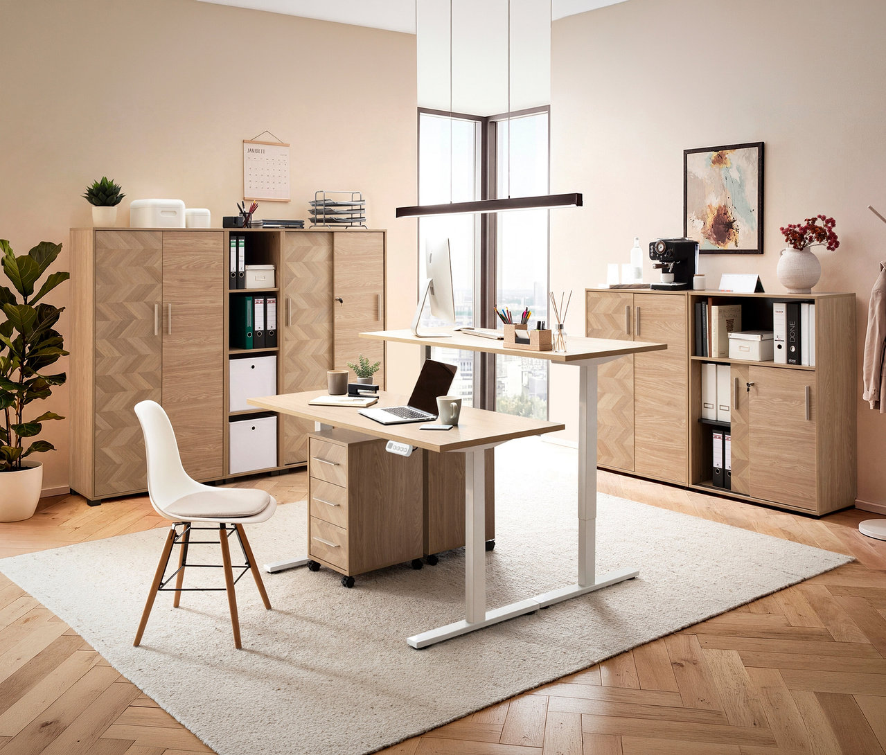 Büro mit höhenverstellbarem Schreibtisch, Laptop, PC, Bürostuhl, Regalen und Deko auf Teppich und Parkettboden.