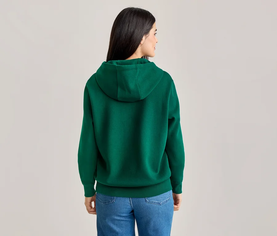 Rückansicht einer Frau mit langen, dunklen Haaren, die einen grünen Hoodie und blaue Jeans trägt.