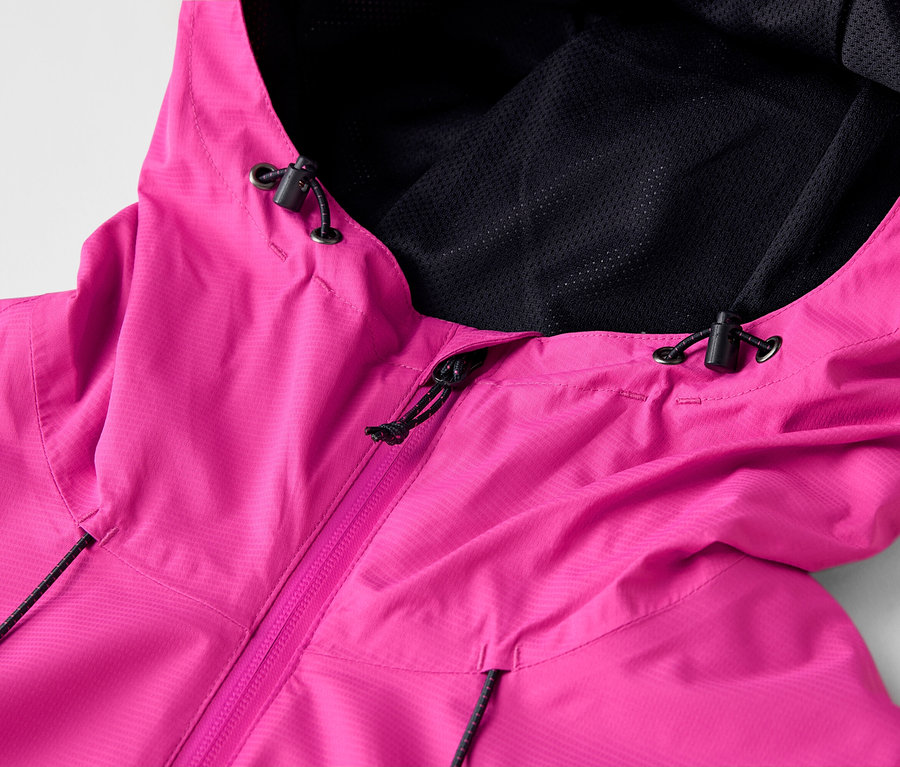 Nahaufnahme einer pinkfarbenen Regenjacke mit Kapuze und schwarzem Netzfutter.
