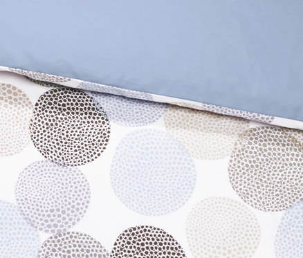 Detailansicht von Satin-Wendebettwäsche mit Kreis-Muster und blauer Oberseite.