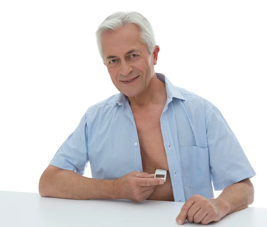 Mann hält ein mobiles EKG-Gerät Beurer »ME 90« an seine Brust.