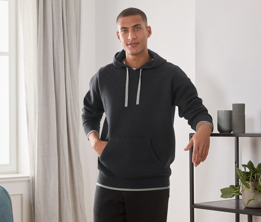Mann posiert im Strick-Hoodie.