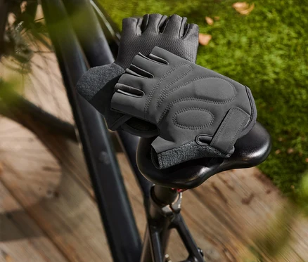 Zwei Fahrrad-Handschuhe liegen auf einem Fahrradsattel.