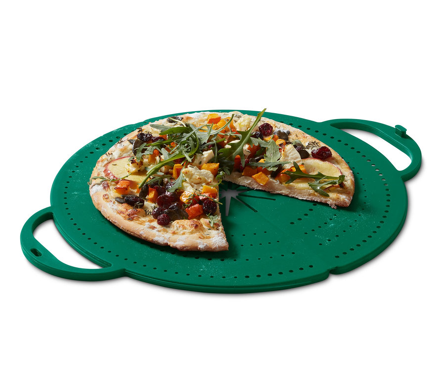Pizza mit fehlendem Stück auf einem grünen 4-in-1-Pfannen-Spritzschutz.