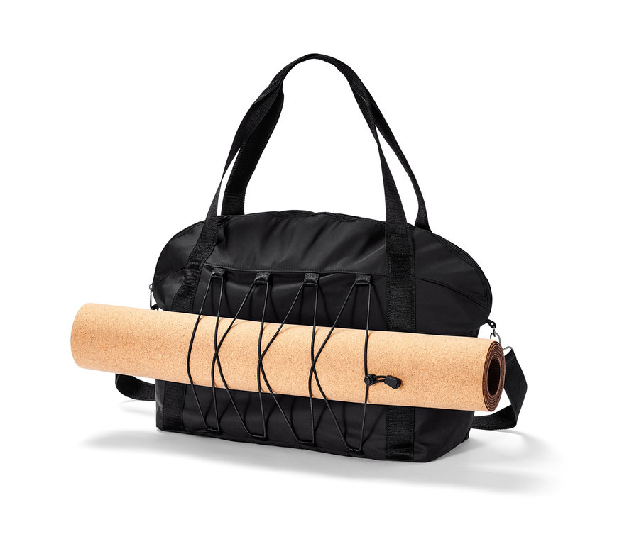 Eine schwarze Sporttasche mit einer zusammengerollten Trainingsmatte.