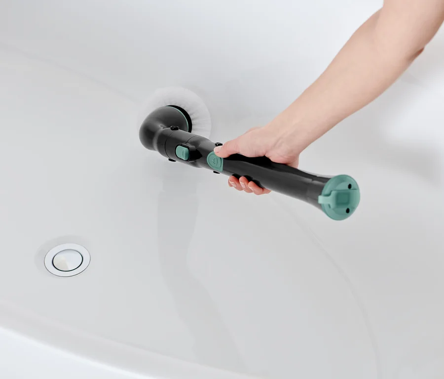 Frau reinigt weiße Badewanne mit elektrischer Profi-Reinigungsbürste.