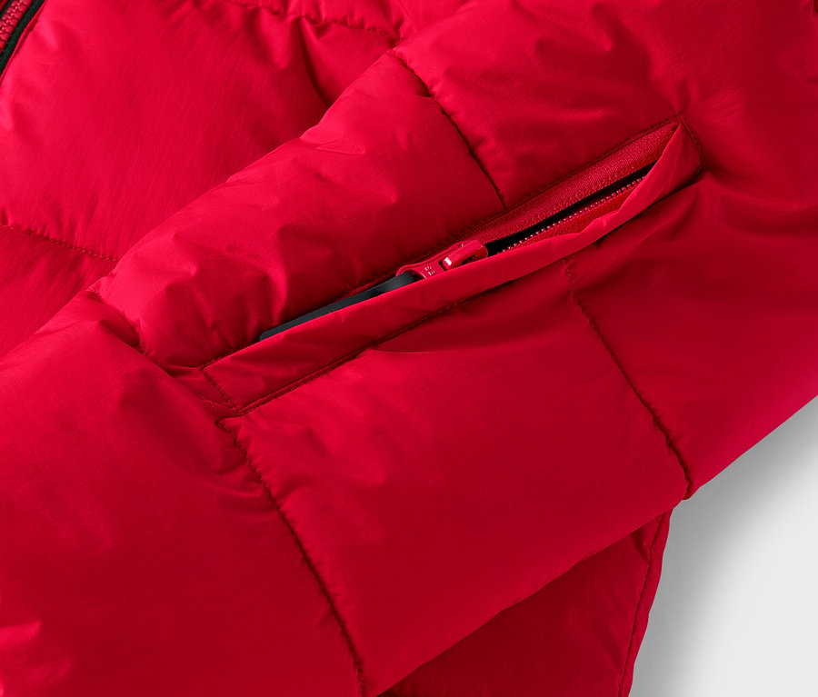 Detailaufnahme einer roten Steppjacke mit Reißverschlusstasche.