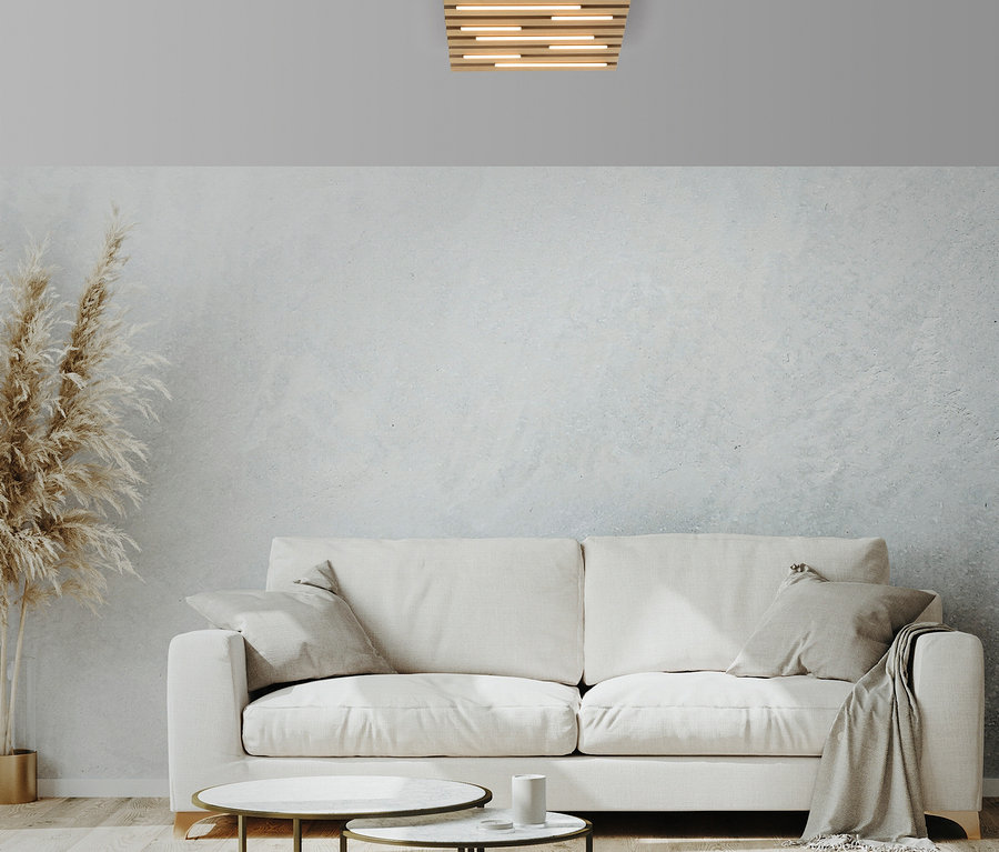 Wohnzimmer mit weißem Sofa, zwei Tischen und Deckenleuchte.