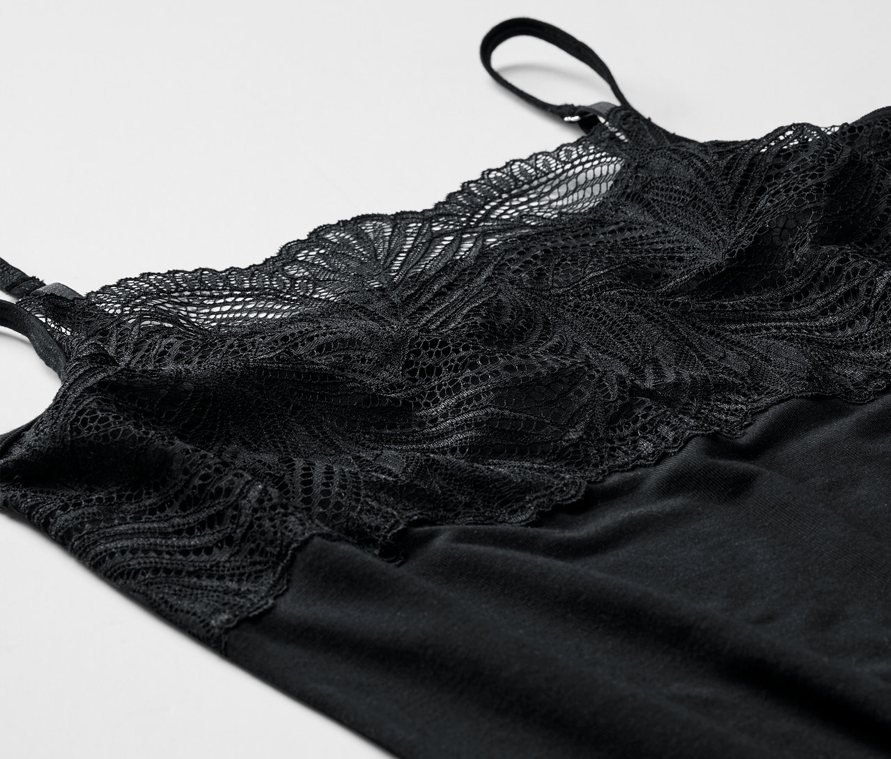 Schwarzes Modal-Hemdchen mit Spitze auf weißem Hintergrund.