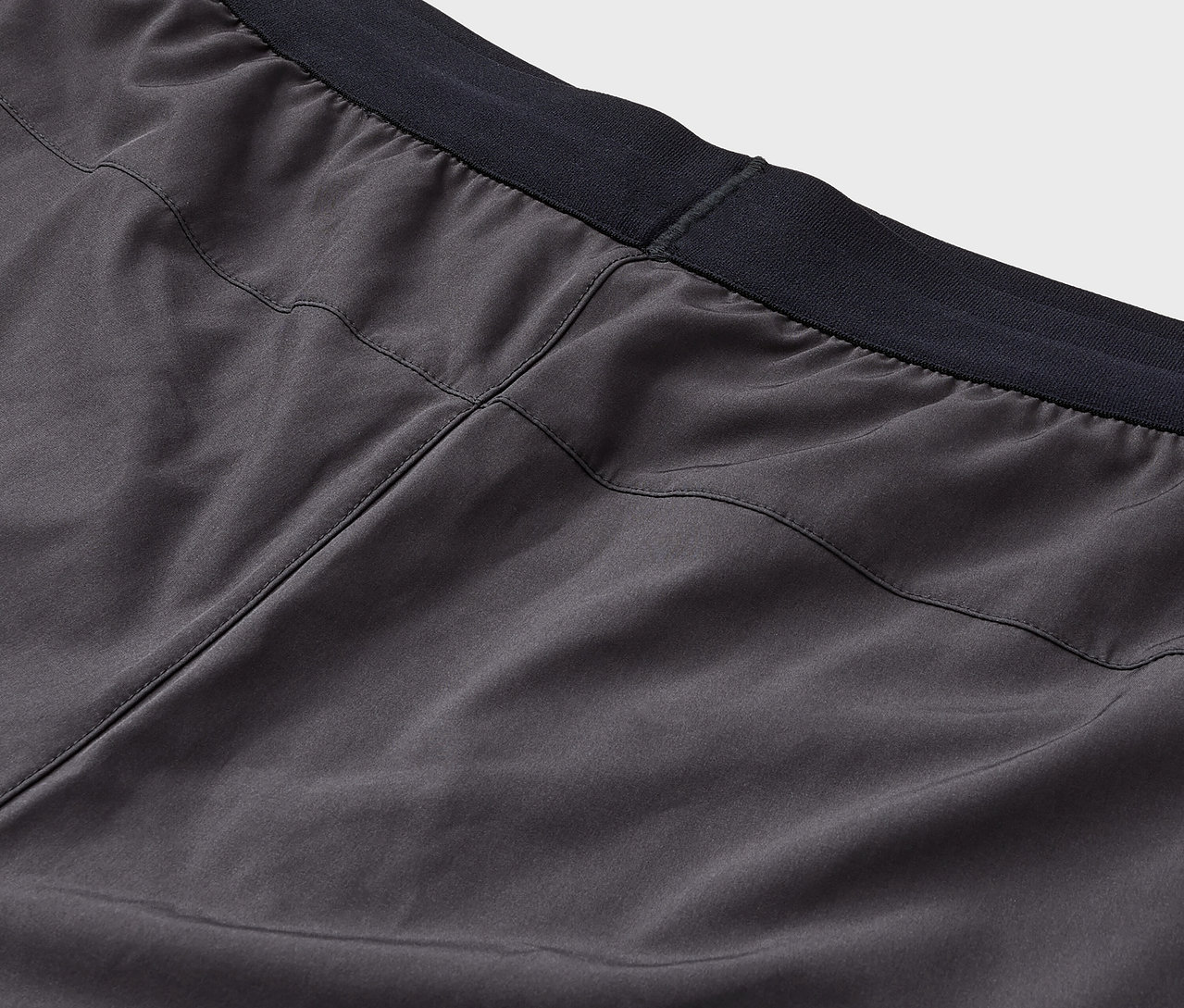 Detailaufnahme von grauen Shorts mit schwarzem Bund.