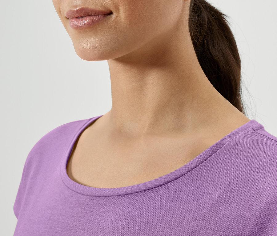 Detailansicht vom Hals einer Frau in einem lila T-Shirt.