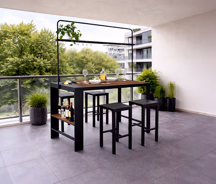 Auf einer Terrasse steht ein Leco Bartisch mit vier Hockern, dekoriert mit Pflanzen, Gläsern, Geschirr und Getränken.