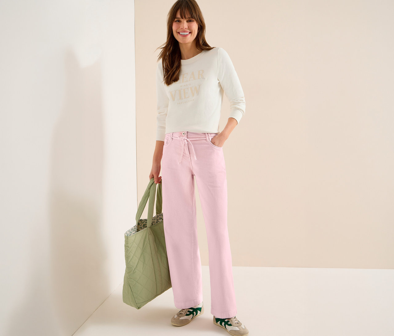 Frau mit Tasche trägt helles Oberteil und CECIL Jeans »Neele« in Rosa.