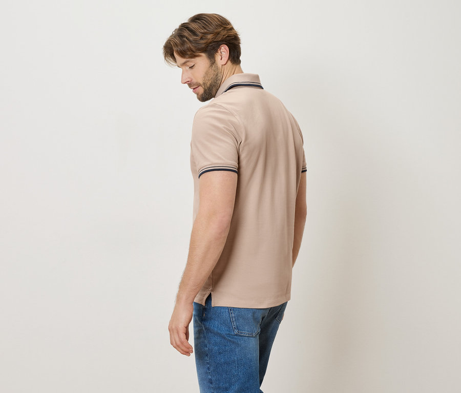 Mann von hinten in beigem Poloshirt und Jeans