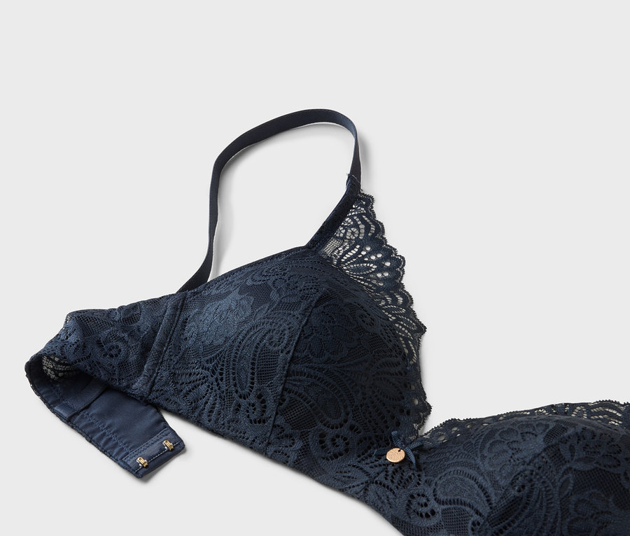 Nahaufnahme eines marineblauen BHs aus Spitze mit verstellbarem Träger.