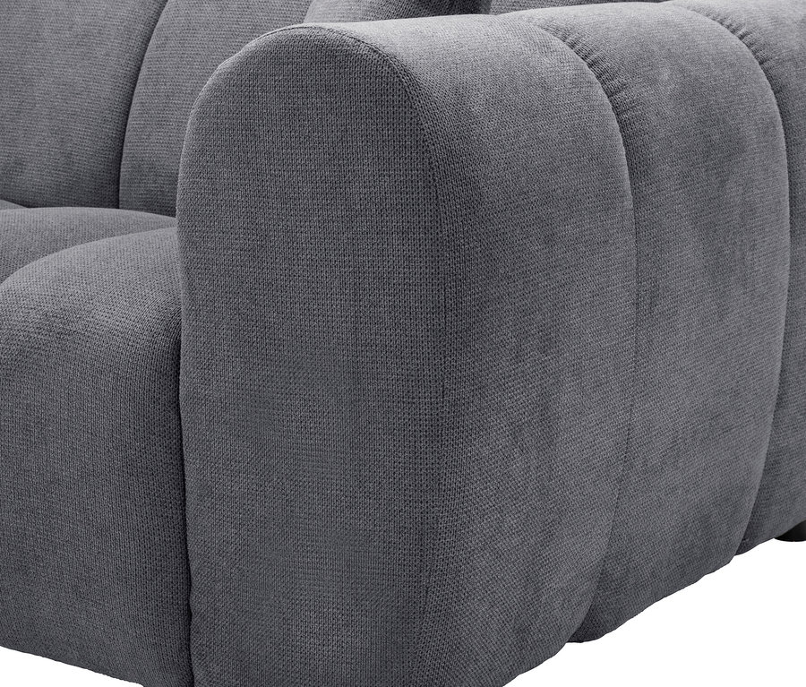 Nahaufnahme der Armlehne eines grauen Sofas.