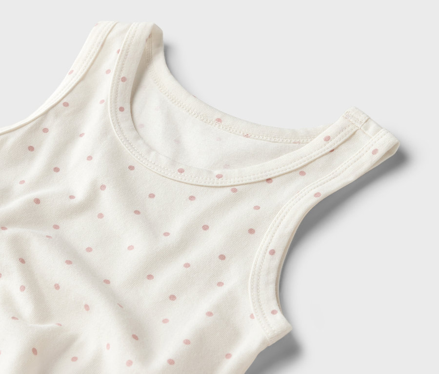 Nahaufnahme eines weißen Tanktops mit rosa Punkten.