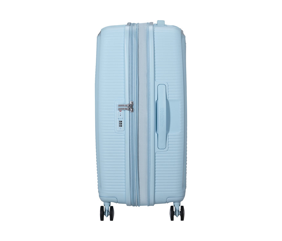 American Tourister Hartschalen-Koffer Soundbox Spinner in Pastellblau, mit horizontalen Rillen, Reißverschluss, Zahlenschloss, seitlichem Griff und vier Rollen.