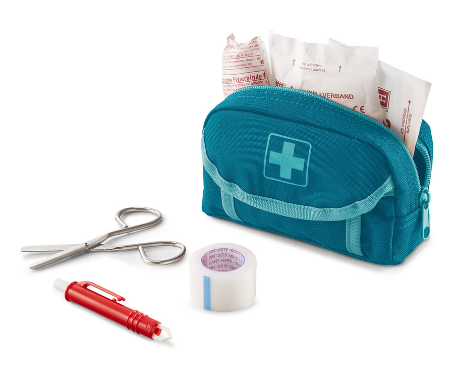 Eine blaue Erste-Hilfe-Tasche mit einem weißen Kreuz, eine Schere, ein Pflaster und ein Stift auf einem weißen Hintergrund.
