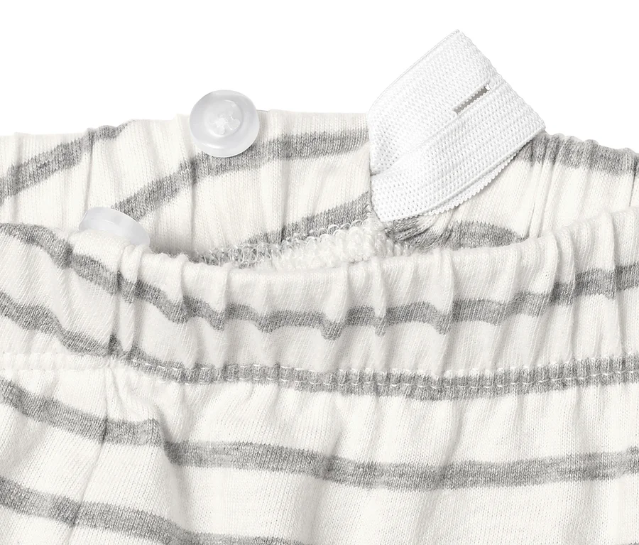 Detailansicht eines Baby-Starter-Sets aus Bio-Baumwolle mit Knöpfen und Streifen.