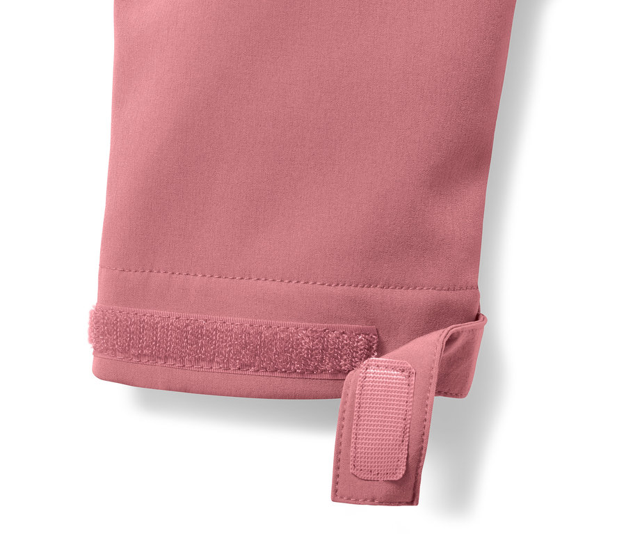 Detailansicht eines rosafarbenen Softshell-Mantels mit Klettverschluss am Ärmel.