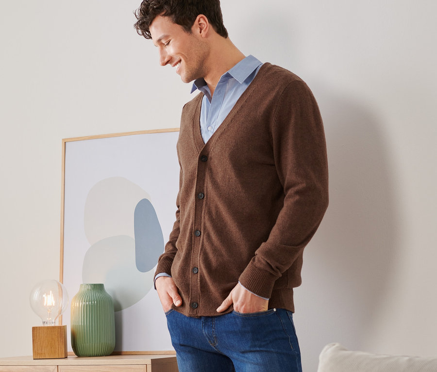 Mann trägt braunen Cardigan.