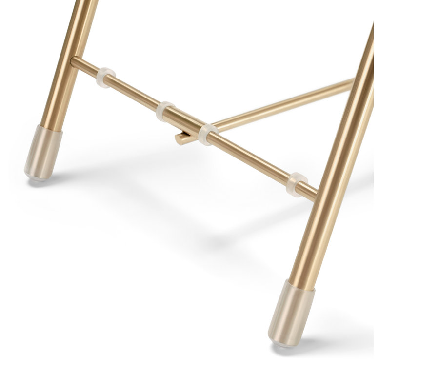 Detailaufnahme einer Etagere mit goldenen Metallbeinen.