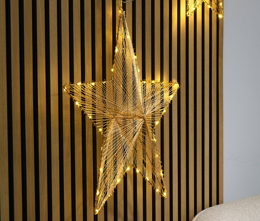 Großer LED-Stern-Aufhänger vor Holzwand.