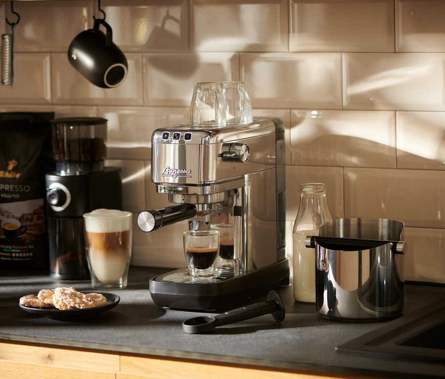 Eine silberne »Lapressa« Siebträgermaschine bereitet Espresso in einem Glas zu.
