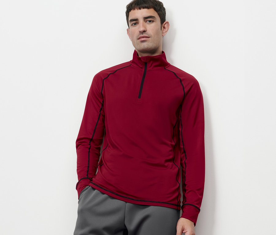 Mann trägt ein rotes Thermofunktionsshirt.