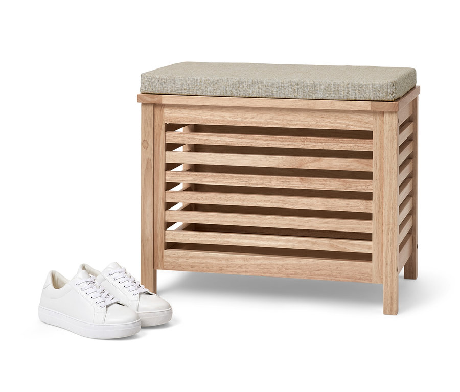 Massivholz-Sitztruhe mit Kissen und weiße Turnschuhe.