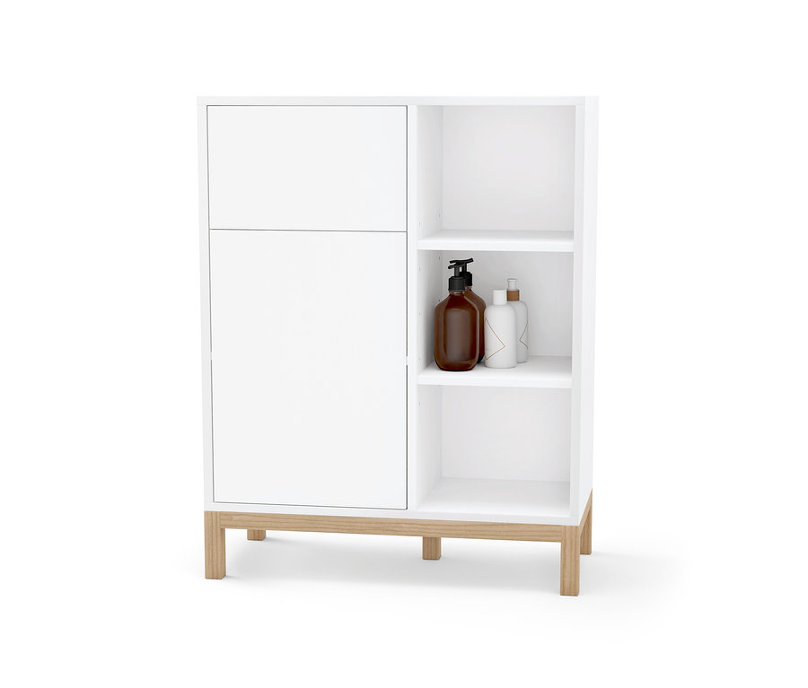 Weißes Bad-Sideboard mit Tür und offenen Regalen, auf denen Flaschen stehen.