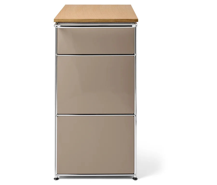 Ein Schrank mit drei beigen Schubladen, einer Holzplatte und einem Chromrahmen.