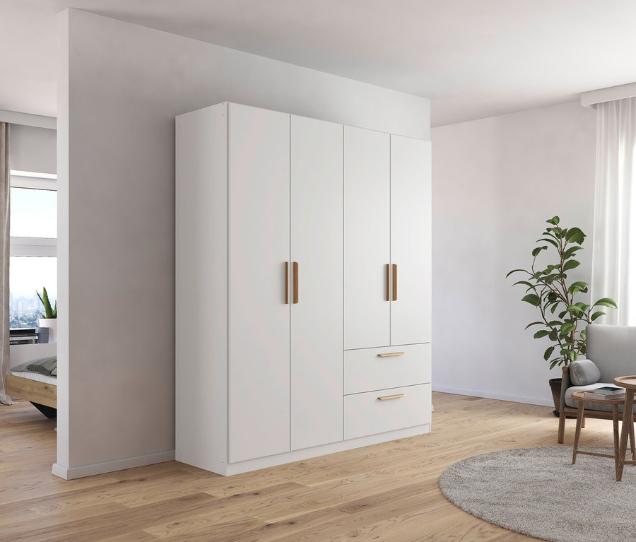 Ein Zimmer mit einem weißen, 4-türigen Drehtürenschrank »Skandi« von Rauch, einem grauen Sessel und einem Couchtisch aus Holz.