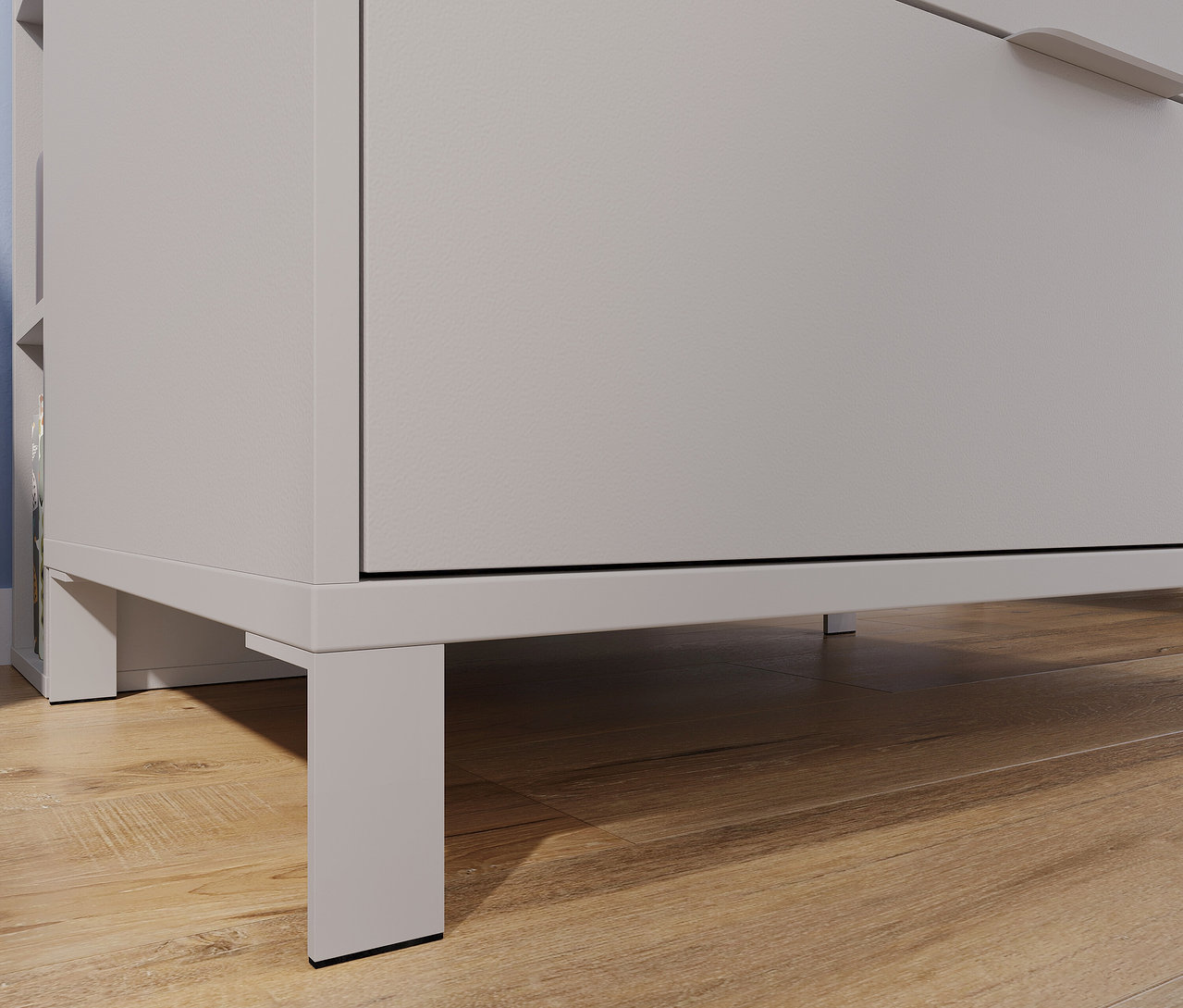 Detailaufnahme einer grauen, breiten Wickelkommode »Alkmaar« auf einem Holzboden.