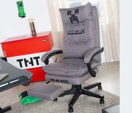 Grauer roba Minecraft Gaming-Stuhl mit Fußstütze steht auf einem Teppich. Im Hintergrund befinden sich eine Truhe mit TNT-Motiv und Minecraft-Dekoration.