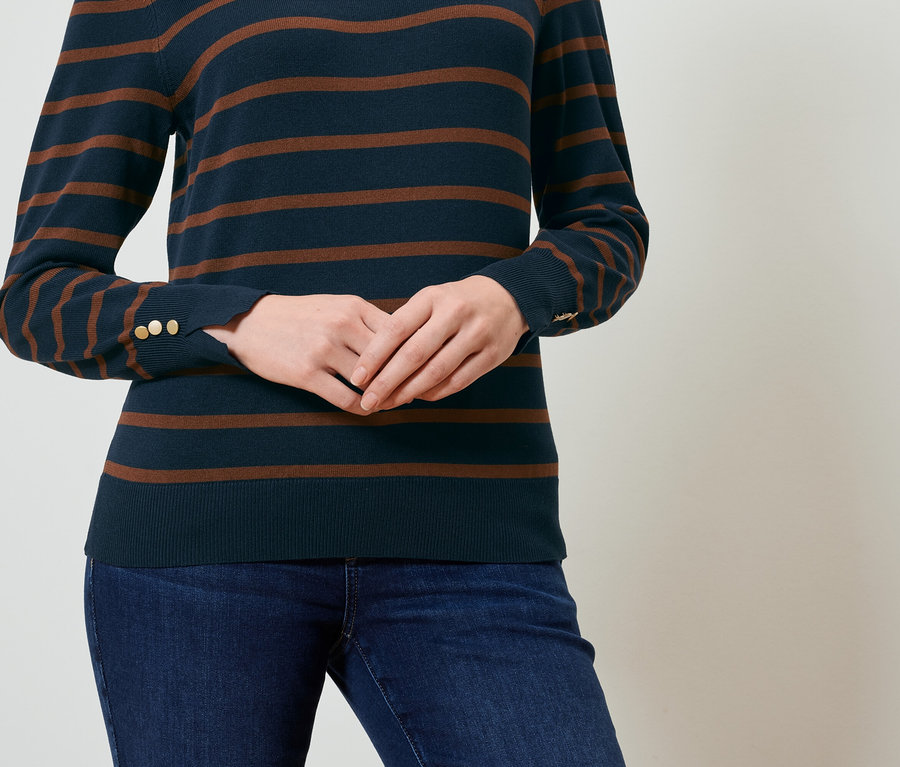 Frau trägt einen gestreiften Pullover und Jeans.