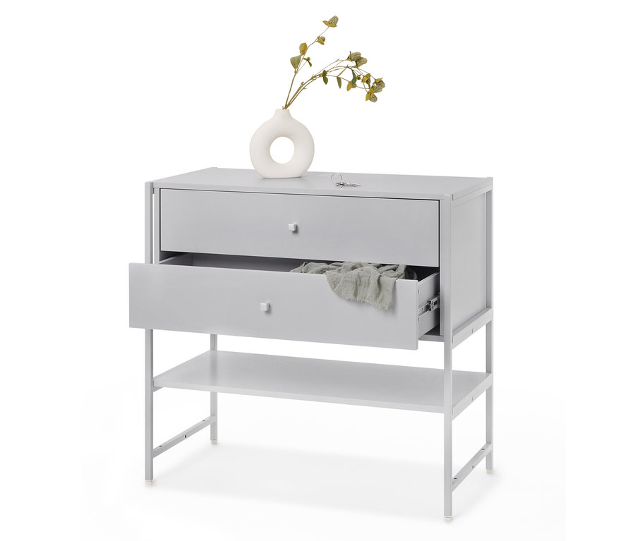 Ein graues Schubladenelement mit zwei Schubladen, von denen eine offen ist, und einem Regal darunter, mit einem Tuch darin und einer Vase mit einer Pflanze darauf.