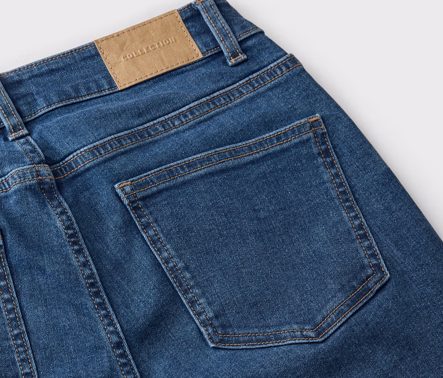 Detailansicht der Rückseite einer blauen Jeans mit einer Gesäßtasche und einem Lederetikett mit der Aufschrift "COLLECTION".