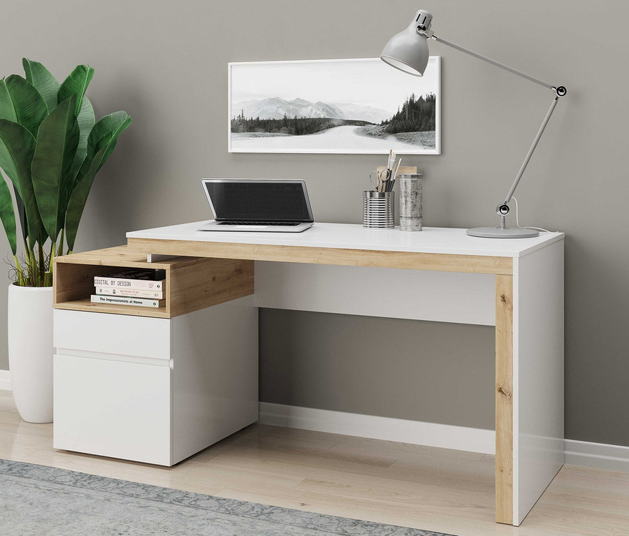 Ein Schreibtisch mit einem Laptop, einer Lampe und einer Pflanze darauf.