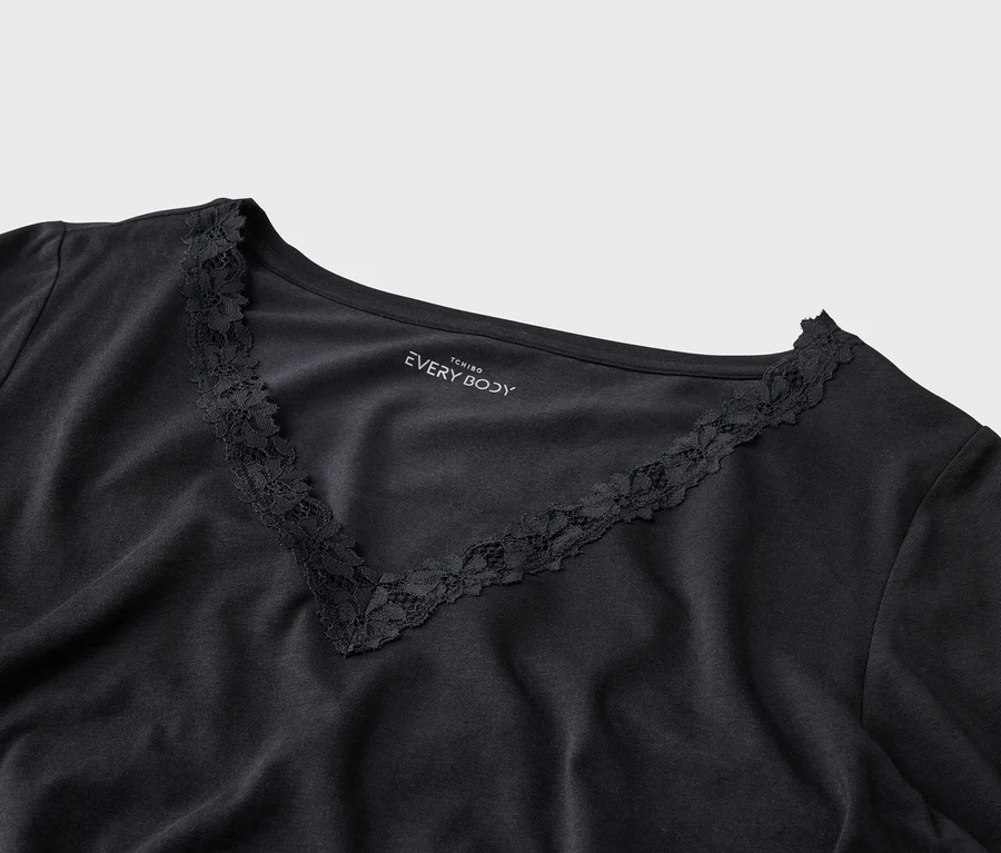 Nahaufnahme eines schwarzen T-Shirts mit V-Ausschnitt und Spitzenbesatz von Tchibo Every Body.